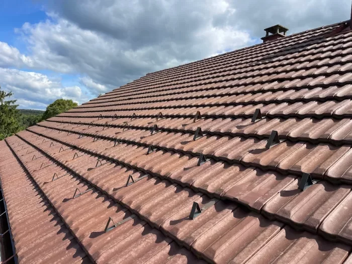 Artisan couvreur r&eacute;alisant l'entretien d'une toiture &agrave; Lons-le-Saunier