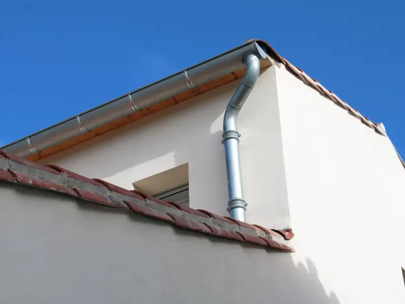 Artisan zingueur installant des finitions en zinc sur une toiture &agrave; Lons-le-Saunier